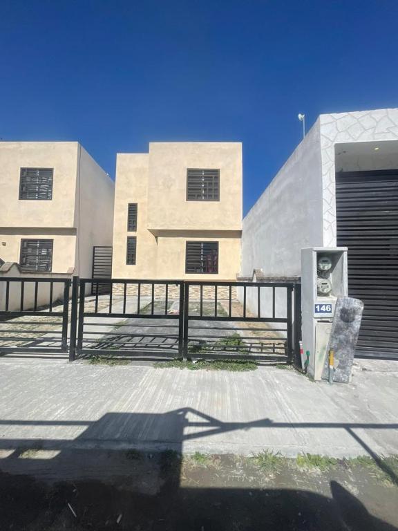 a building with a fence in front of it at Casa arcilla clima total Starlink zona Aeropuerto in Villa Juárez