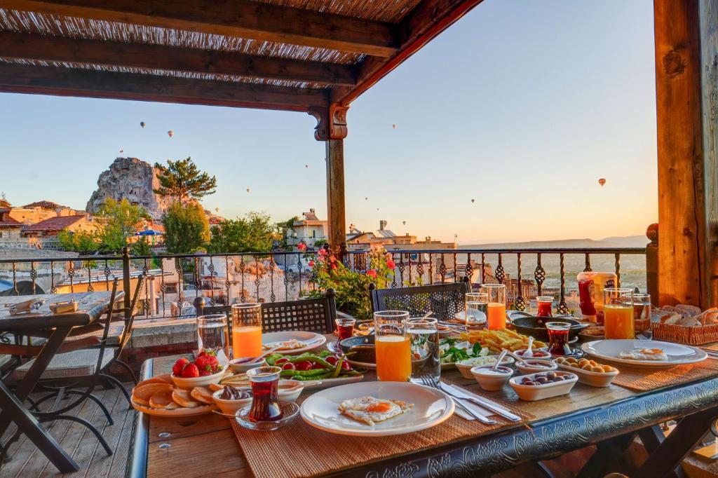 a table with food and a view of the ocean at Vasıl Cave Hotel in Uçhisar