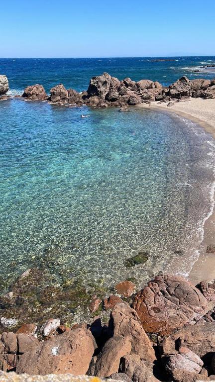 a beach with rocks and the water at Da Marta Appartamento VISTA MARE MOZZAFIATO ISOLA ROSSA in Cascabraga