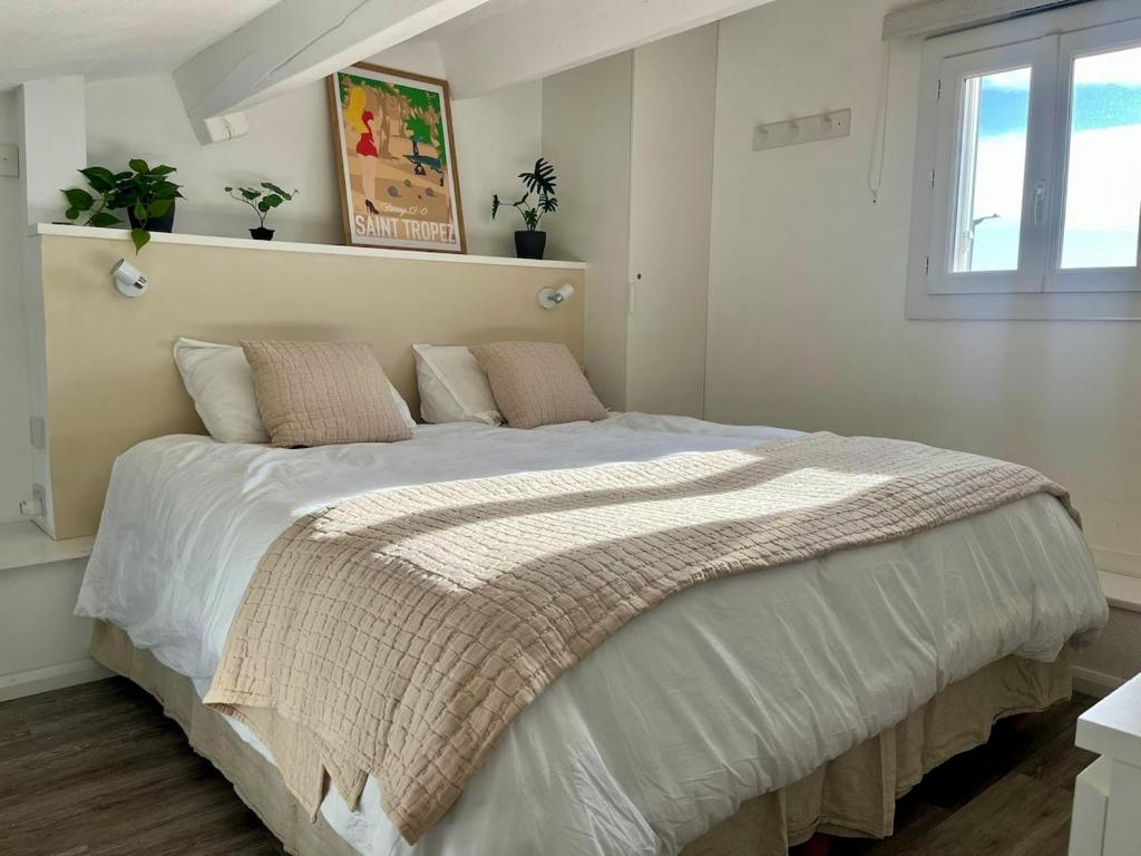 a bedroom with a large bed in a room at Nid du port in Grimaud