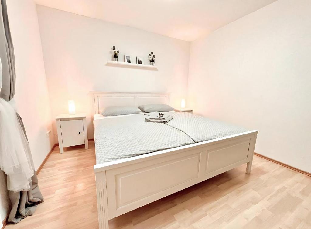 a white bedroom with a bed in a room at Black Forest Valley - Nähe Europa Park & Rulantica in Burgheim