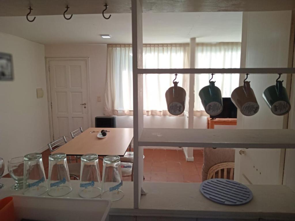 una cocina con una mesa con gafas en un estante en Departamento en complejo ''Los abedules'', en Balcarce