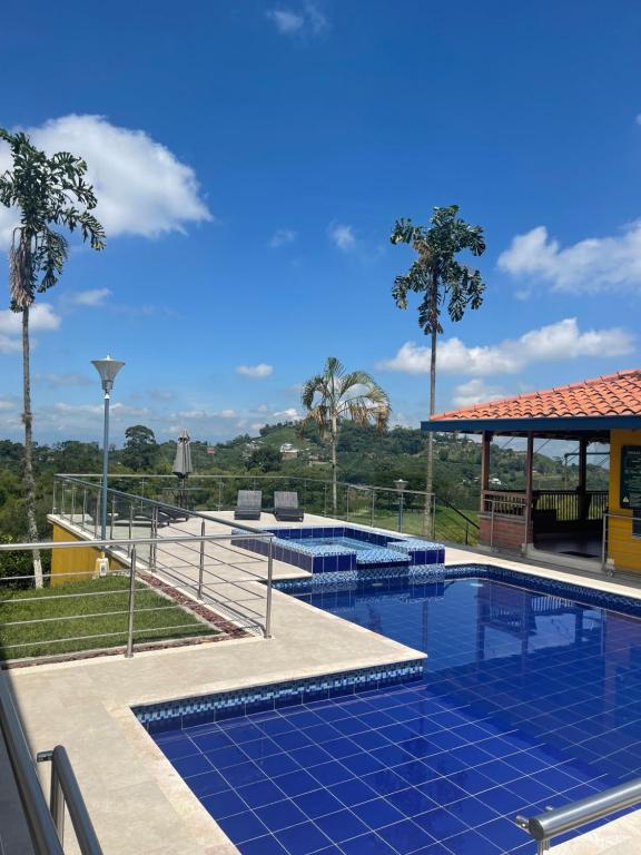 a swimming pool with blue tiles on the ground at Ecohotel Guaduales Nature in Pereira