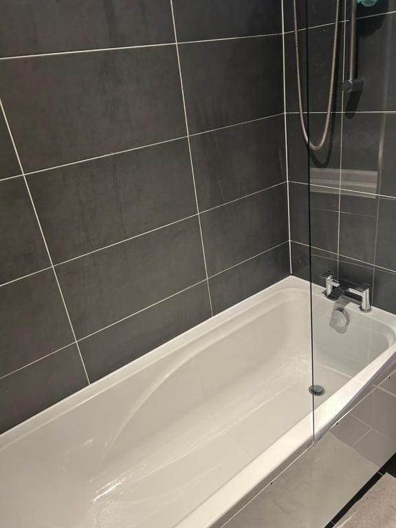 y baño con bañera blanca y ducha. en JM cozy double room with huge garden, en Wainscot