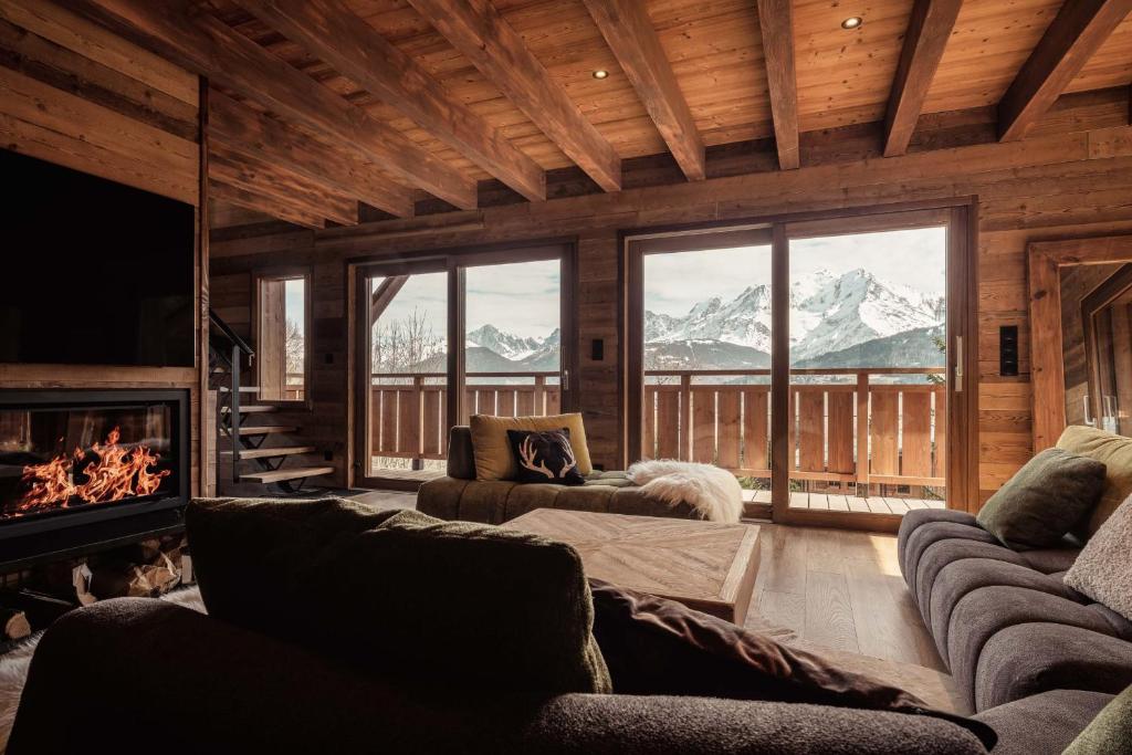 un salon avec cheminée et montagnes dans l'établissement La Combe Blanche - Balcon sur le Mont-Blanc, à Combloux