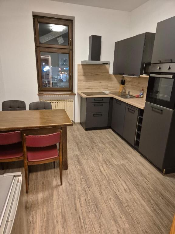 a kitchen with a wooden table and a table and chairs at Privat Apartment 2 Leoben in Leitendorf