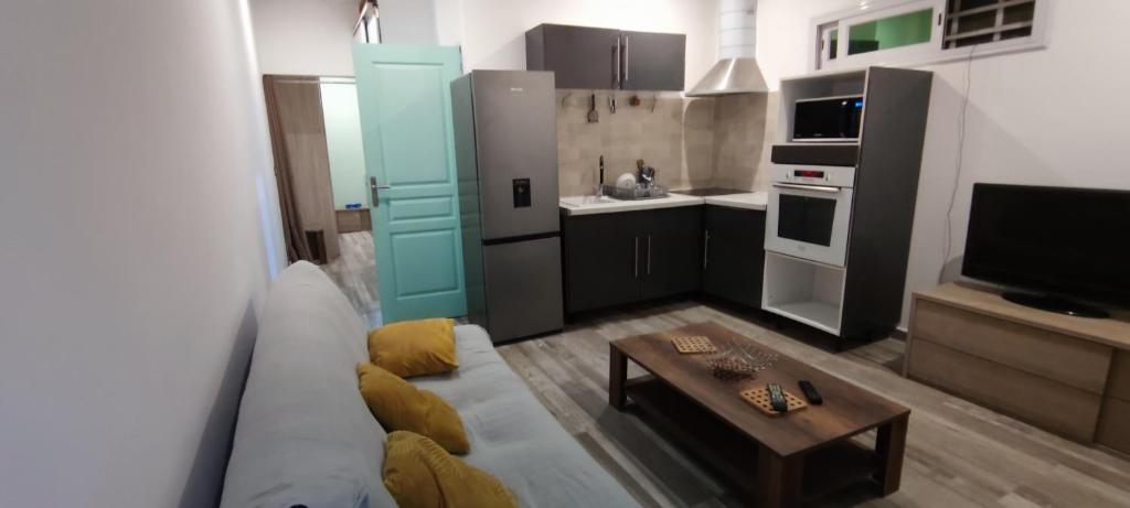ein Wohnzimmer mit einem Sofa und einer kleinen Küche in der Unterkunft Mayecha in Dzaoudzi
