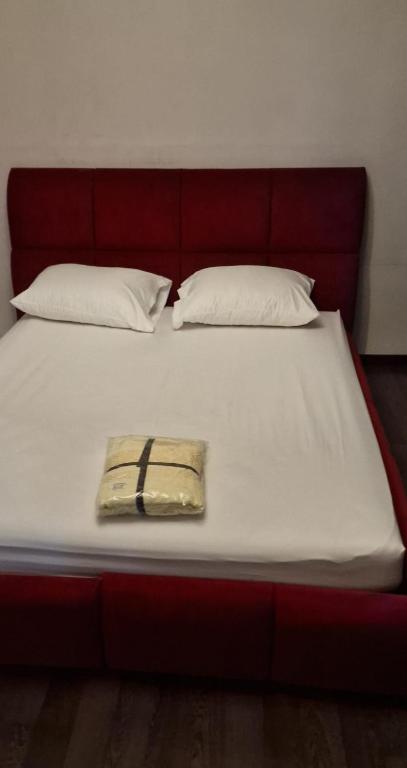 a bed with a red headboard with a purse on it at Appt Fes centre ville in Fez