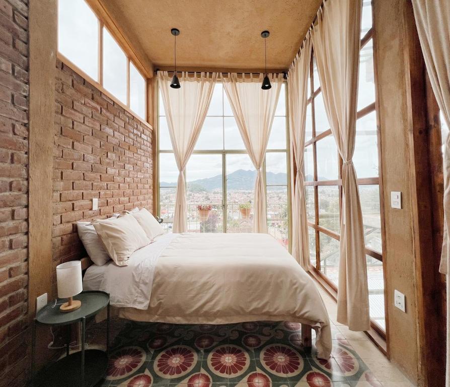 una camera da letto con un letto e una grande finestra di Casa Ocaso downtown terrace amazing views a San Cristóbal de Las Casas