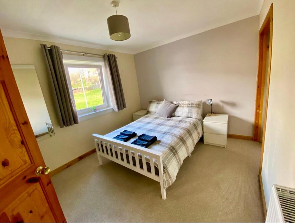 a small bedroom with a bed with a window at Fort William - Highland holiday home in Fort William