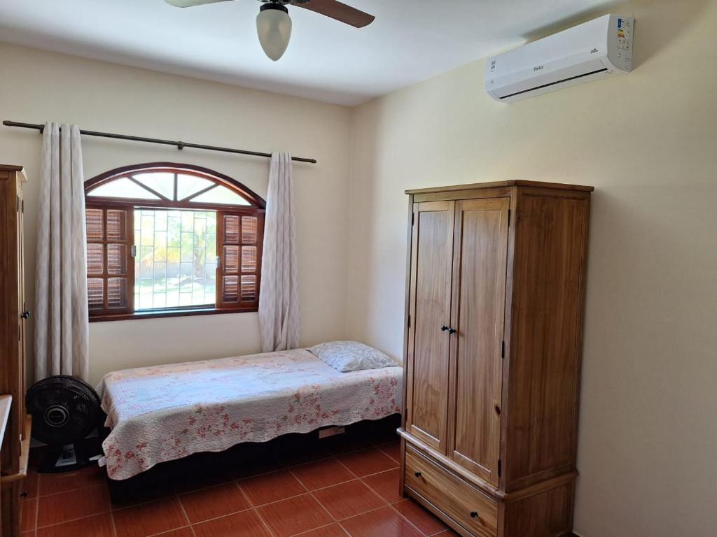 a bedroom with a bed and a dresser and a window at Pouso Zen in Araruama