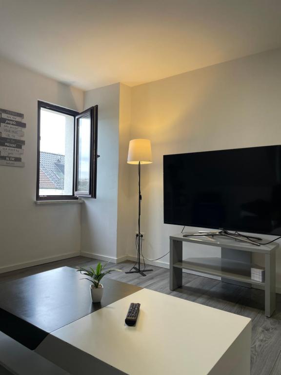 a living room with a large flat screen tv at HomeBerg Duisburg - feine 3 Zimmer, 4 Betten, 60qm in Top Lage in Duisburg