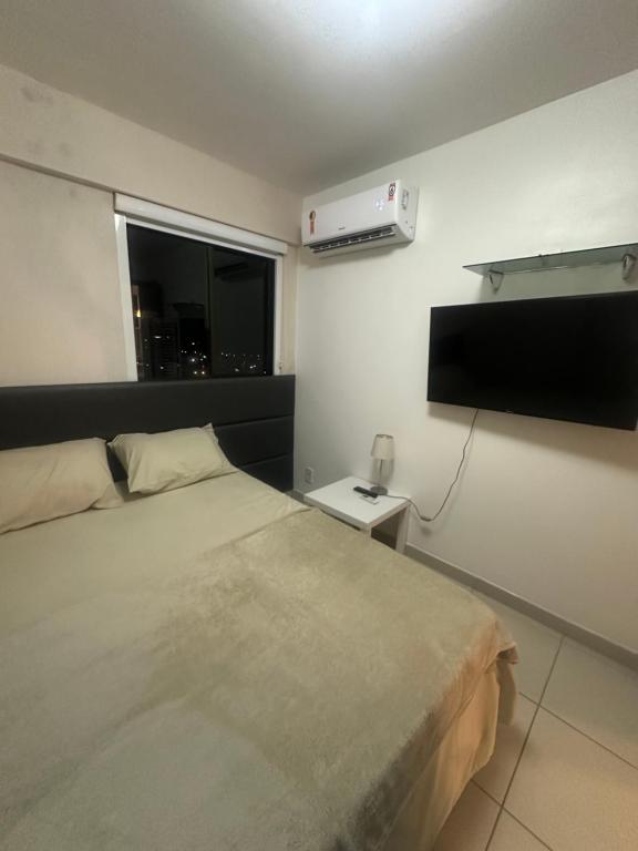 una camera da letto con un letto e una TV a schermo piatto di Flat luxo Shopping Rio Mar - Beach class Boa Viagem Recife - Piscina Rooftop a Recife