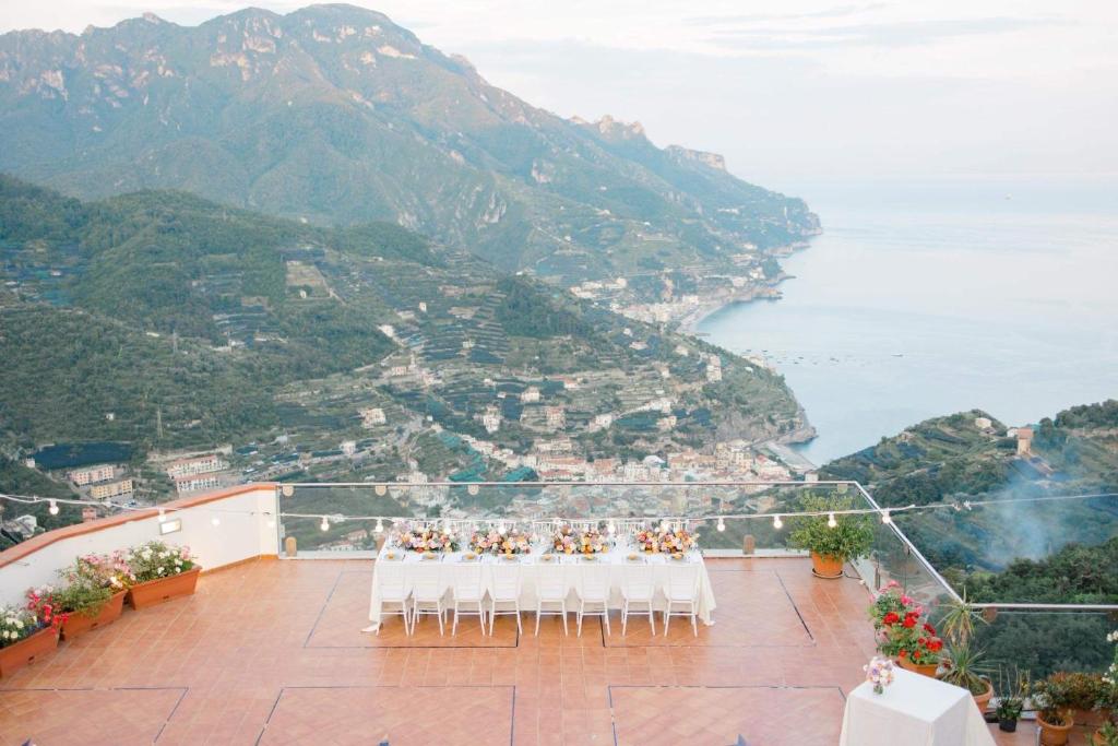 a group of tables and chairs on a balcony with the ocean at Hotel Bonadies in Ravello