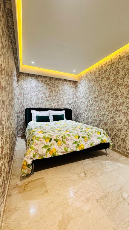 a bedroom with a bed with a floral comforter at Racine Studio bd Anfa in Casablanca