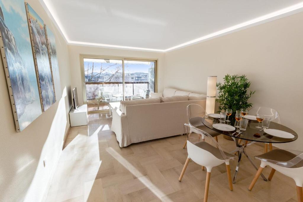 un salon avec une table et un canapé dans l'établissement Le Magali - Hypercentre - Parking - Spacious - AC, au Cannet