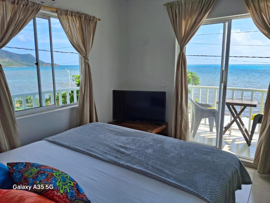 プロビデンシアにあるApartamentos frente al mar Bahia Rocky Pointのベッドがあり海が見える寝室