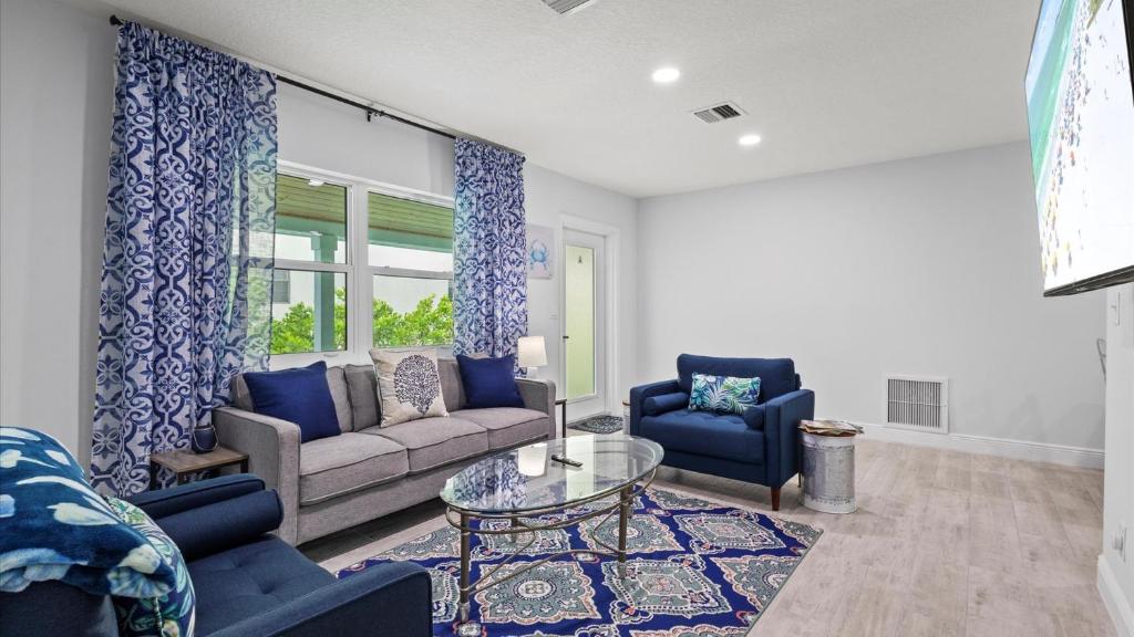 Una sala de estar con un sofá y sillas y una mesa. en Ocean Drive Villas- Unit A, en Fort Pierce