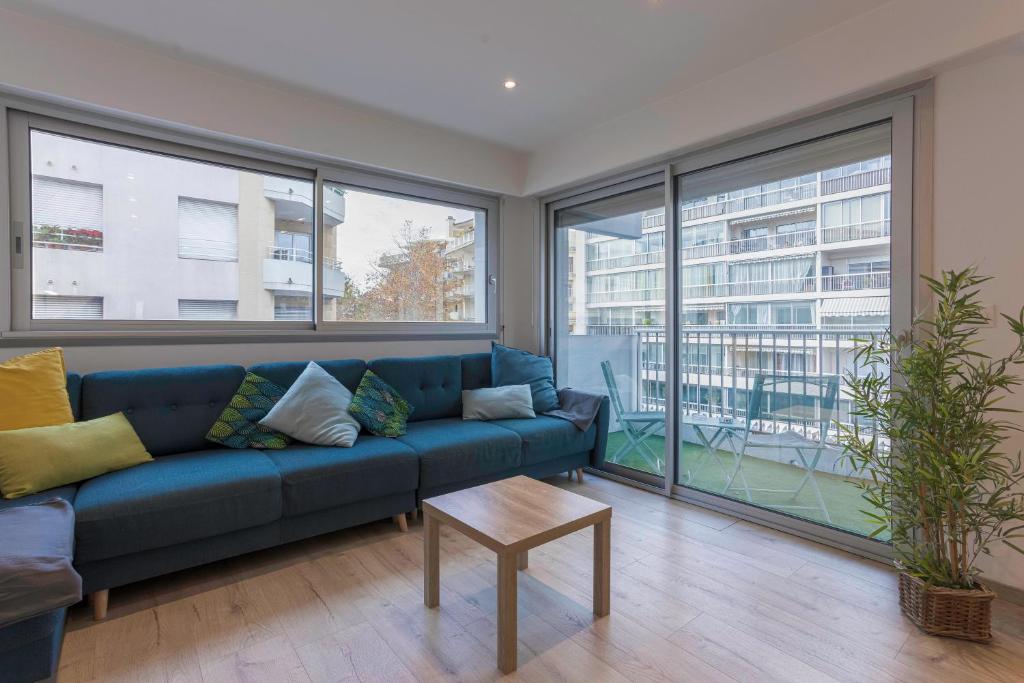 - un salon avec un canapé bleu et de grandes fenêtres dans l'établissement 