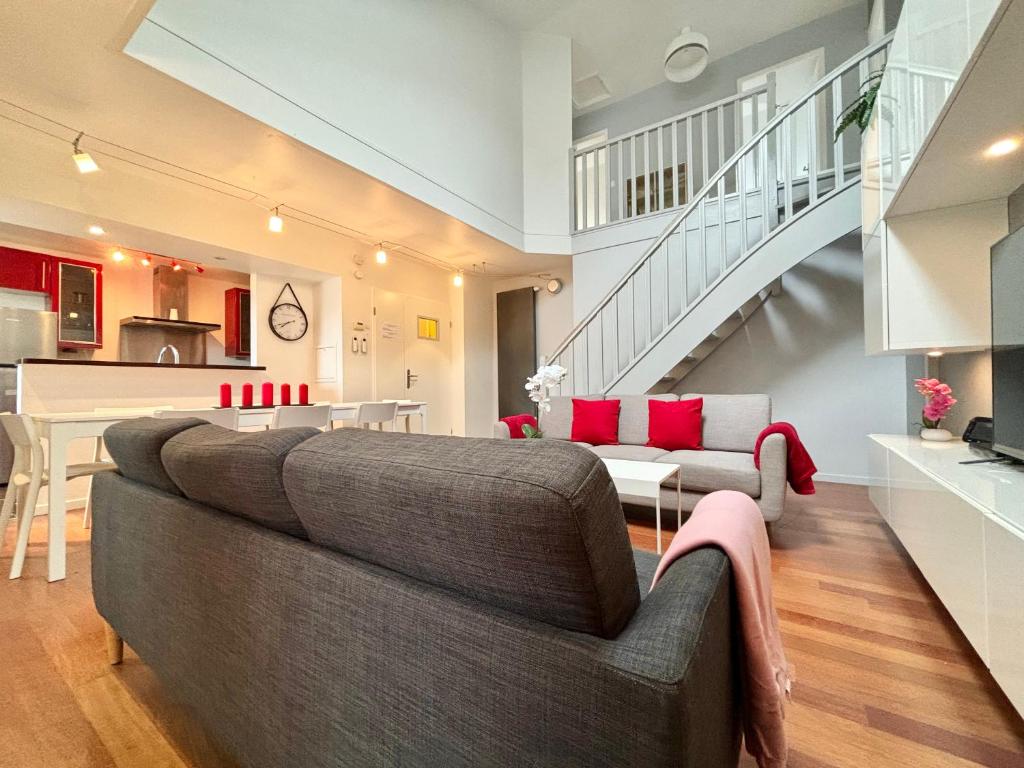 Il comprend un salon avec un canapé gris et une cuisine. dans l'établissement Family Duplex Disneyland Paris - Rentaway BnB, à Magny-le-Hongre