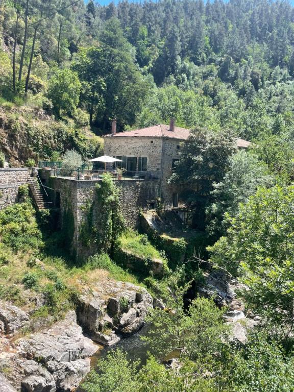une maison sur une colline à côté d'une rivière dans l'établissement Le Buis Domaine, à Saint-Sauveur-de-Montagut