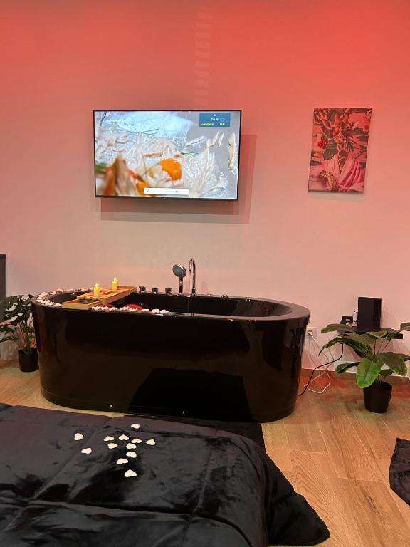 a large black tub in a room with a flat screen tv at Sweet dreams in Palermo