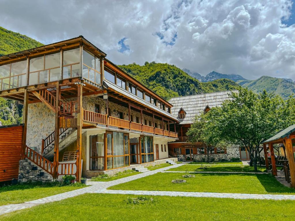 una vista esterna di un edificio con montagne sullo sfondo di Logu i Harushave a Theth