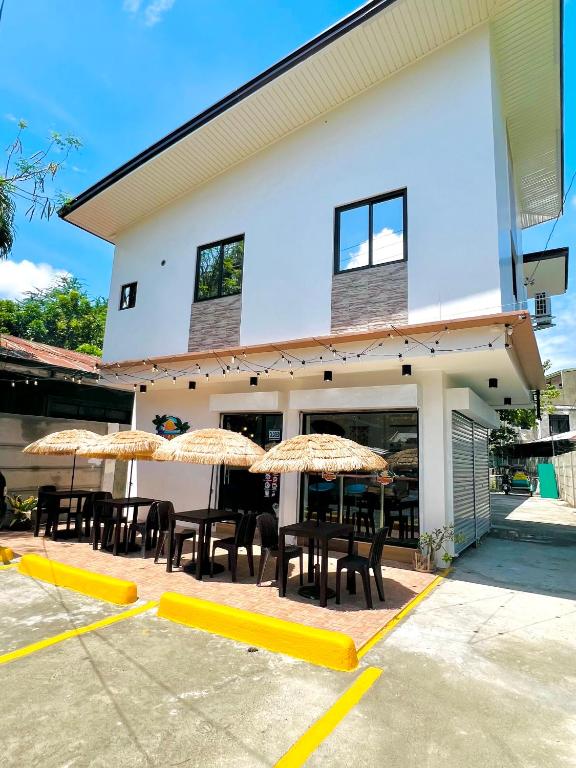 a group of chairs and umbrellas in front of a building at Casa Mia Apartments in Villasis