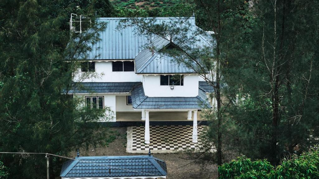 einen Blick über ein Haus mit blauem Dach in der Unterkunft Vagamon Hill Palace Private Villa 3BHK in Vagamon