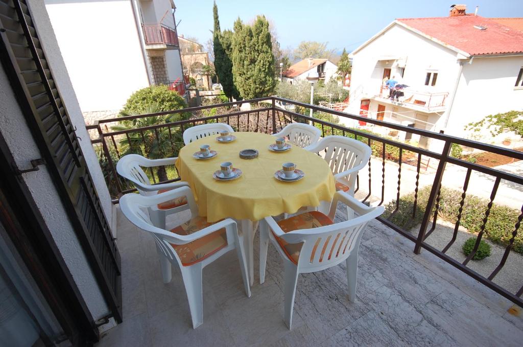 a yellow table with white chairs on a balcony at Apartment Alex in Njivice