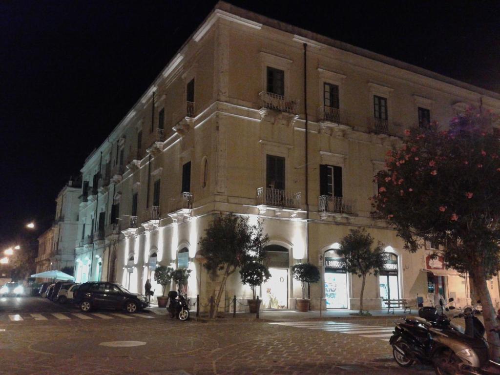 un grand bâtiment situé dans une rue de la ville la nuit dans l'établissement B&B CARAVAGGIO SIRACUSA -200 Metres from Ortigia-, à Syracuse