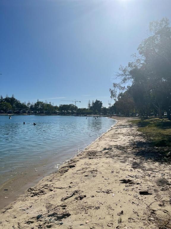 a beach with people swimming in the water at Tallebudgera Creek Escape in Gold Coast