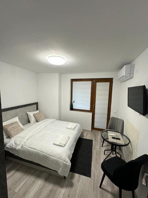 a bedroom with a bed and a table and a tv at Star in Varna City