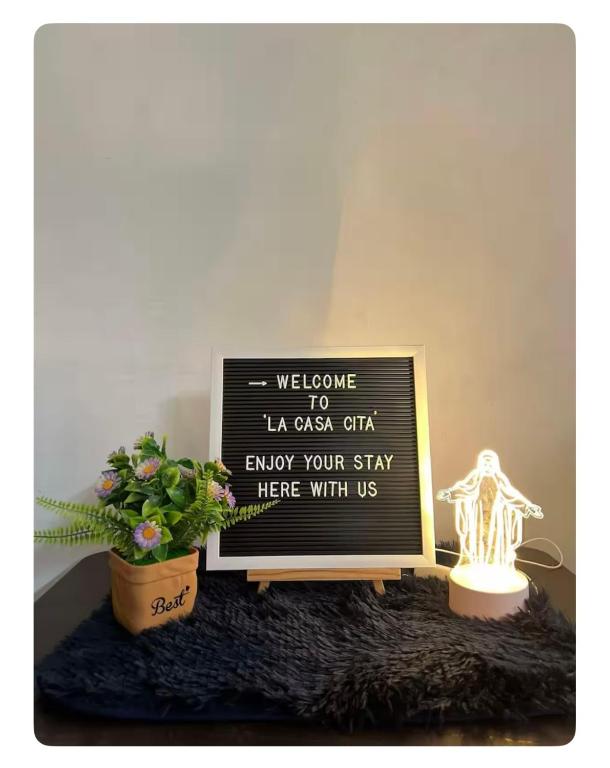a sign sitting on a table with a potted plant at La Casa Cita in Indang