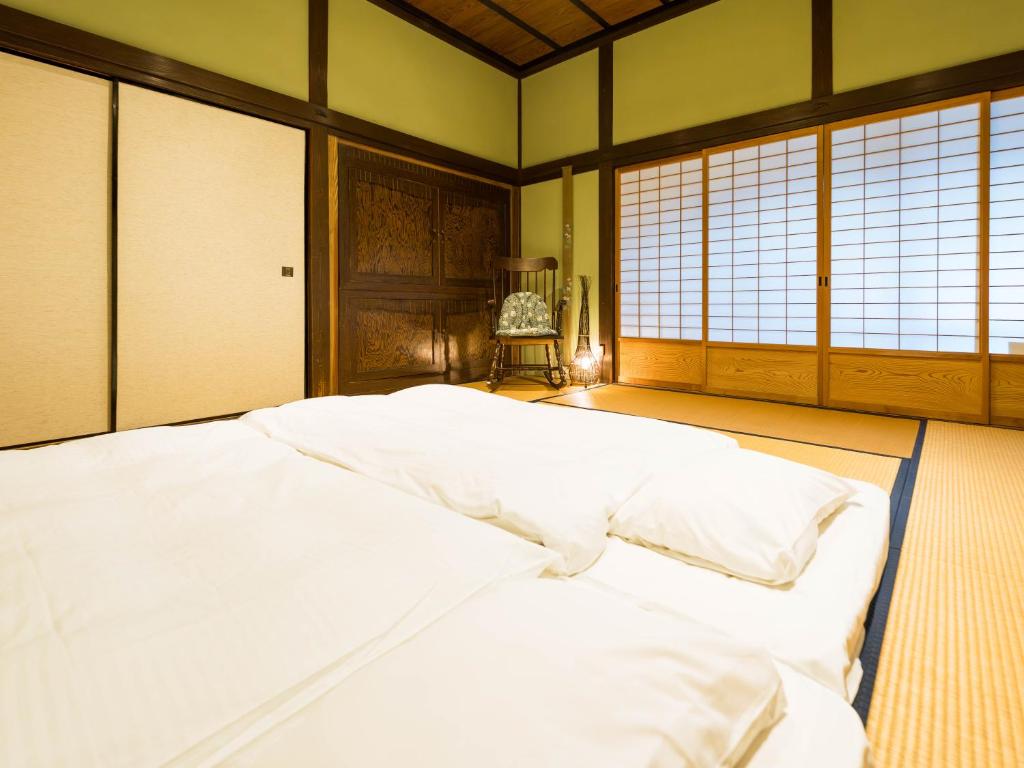 Postel nebo postele na pokoji v ubytování 平田屋 明治の間 -Hirataya Meiji- 父母ケ浜4分