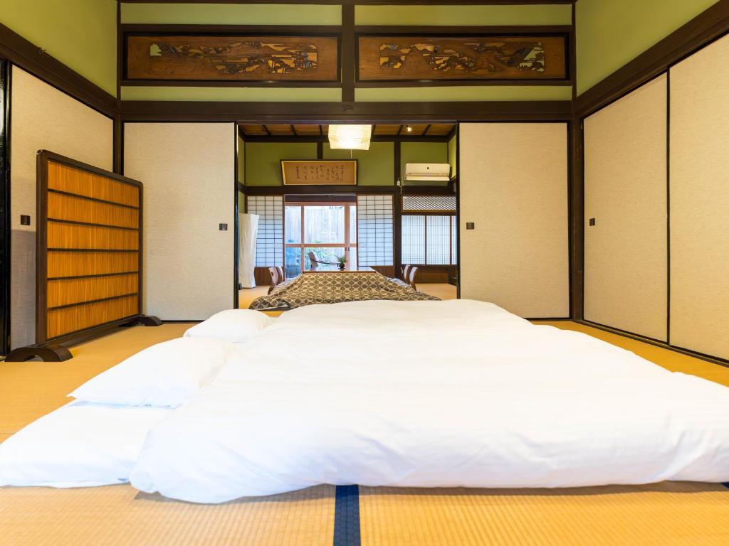 Postel nebo postele na pokoji v ubytování 平田屋 明治の間 -Hirataya Meiji- 父母ケ浜4分