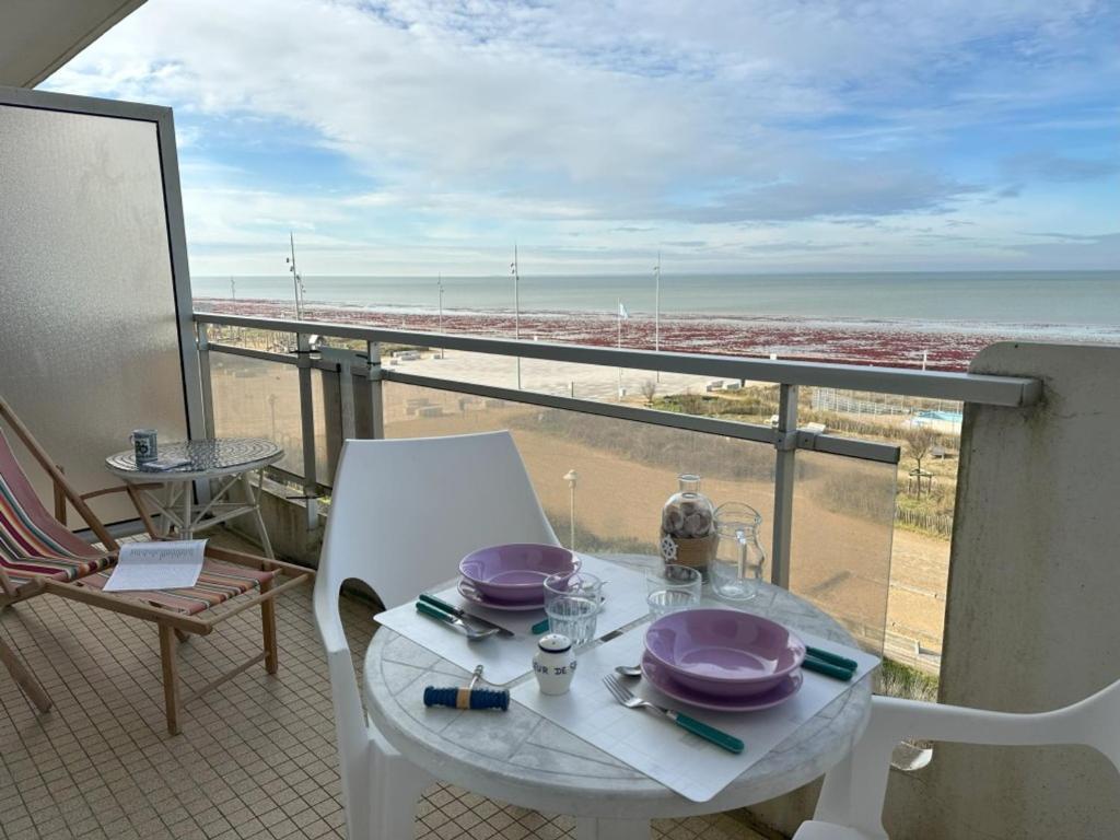 une table et des chaises sur un balcon avec vue sur la plage dans l'établissement Studio bord de mer, balcon, animaux bienvenus, parking - Notre-Dame-de-Monts - FR-1-540-315, à Notre-Dame-de-Monts