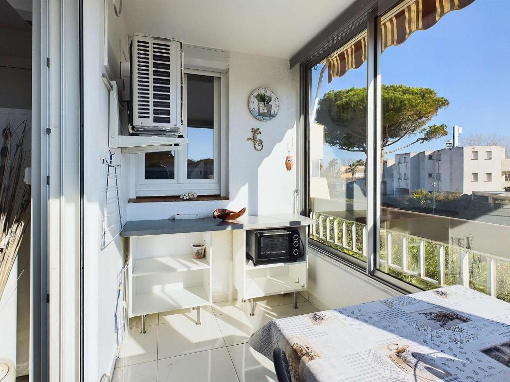 Cette chambre dispose d'un balcon, d'une cuisine et d'une fenêtre. dans l'établissement Appartement climatisé 2 pièces + cabine avec parking au cœur de Marseillan-Plage - FR-1-326-847, à Marseillan