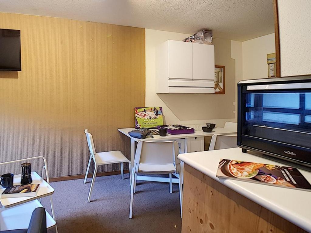 Cette chambre comprend une cuisine avec une table et une télévision. dans l'établissement Studio cabine classique aux Menuires, proche des pistes - FR-1-344-1228, aux Menuires