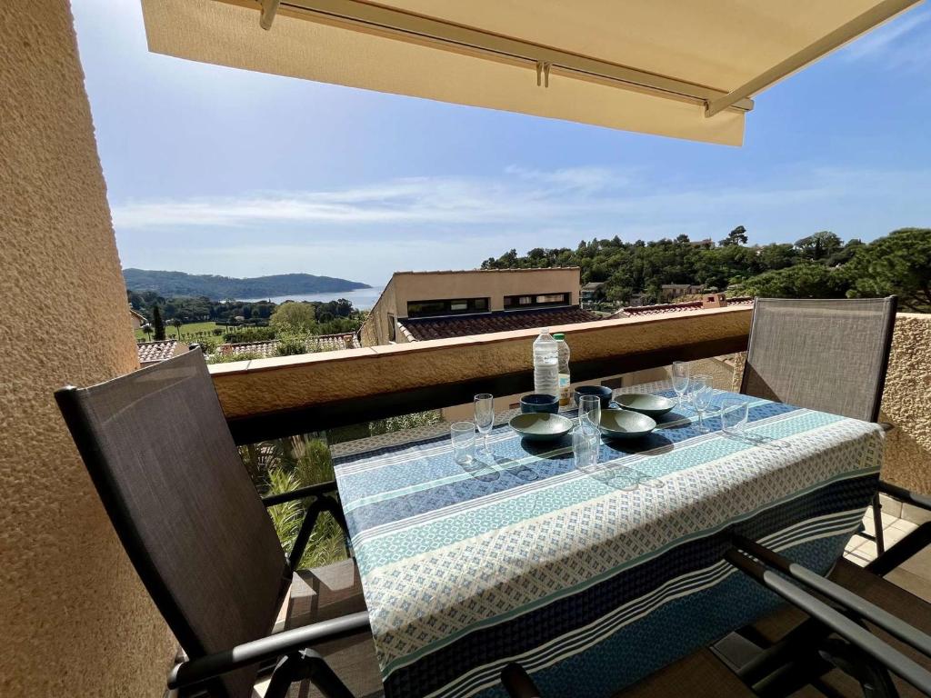 une table avec des bols et des verres sur un balcon dans l'établissement Appartement avec terrasse vue mer et parking à La Croix-Valmer - FR-1-226B-231, à La Croix-Valmer