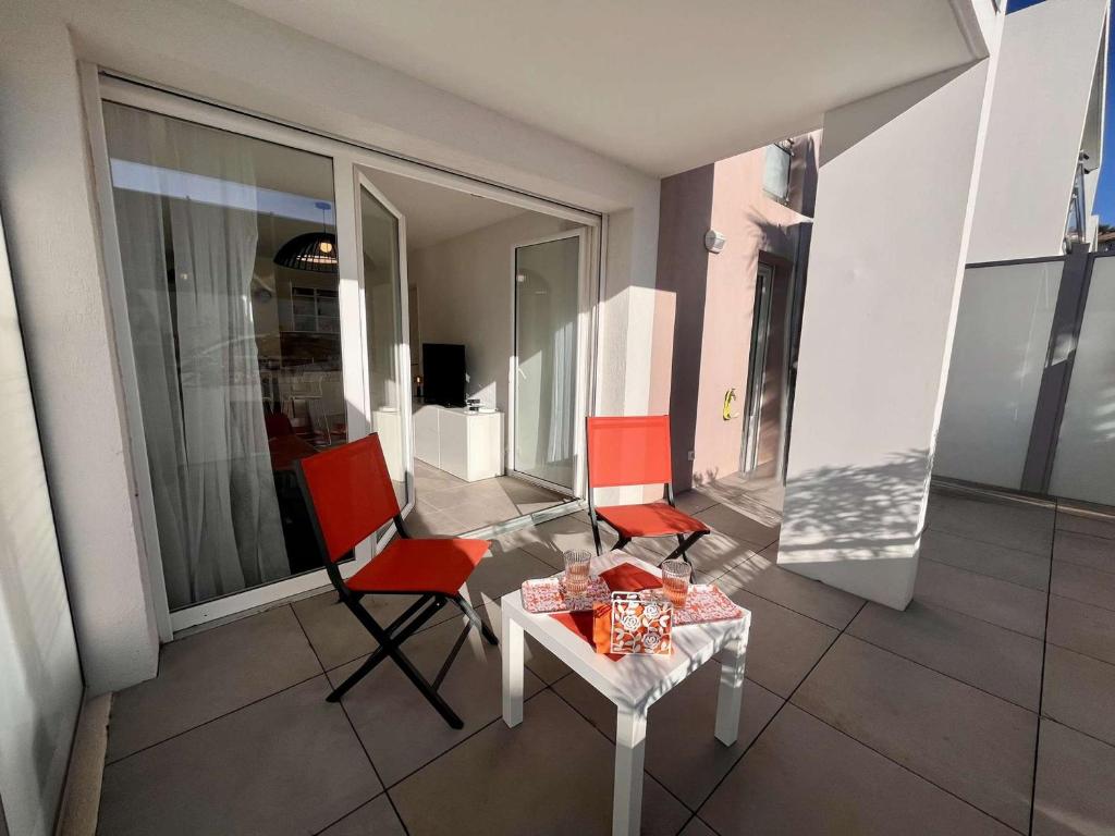 - un balcon avec 2 chaises et une table avec des cadeaux dans l'établissement Appartement T2 bis 40m² avec Terrasse et Parking à Cavalaire-sur-Mer - FR-1-226B-232, à Cavalaire-sur-Mer