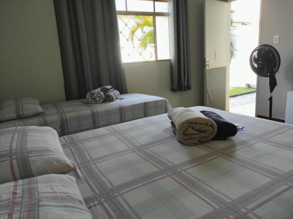 a bedroom with two beds and a window at Quarto privativo no Bairro Santa Mônica in Uberlândia