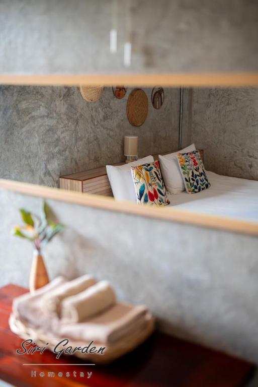 a shelf with a bed with pillows on it at บ้านสวนศิริ Siri Garden in Ban Mang