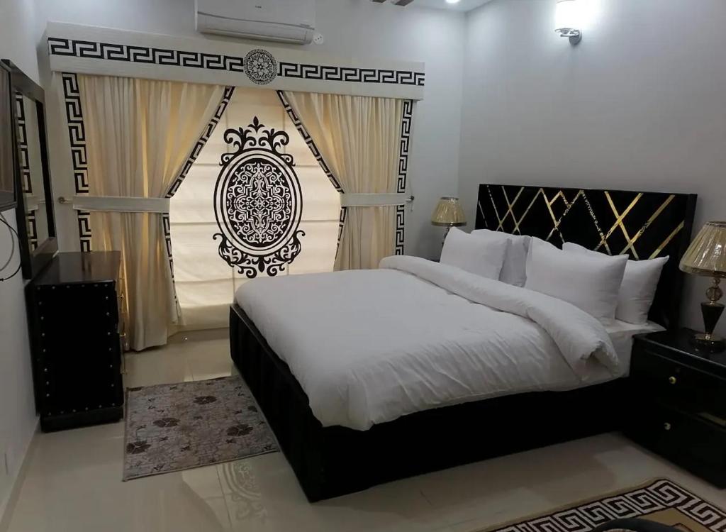 een slaapkamer met een groot bed en een raam bij Family lodges in Islamabad