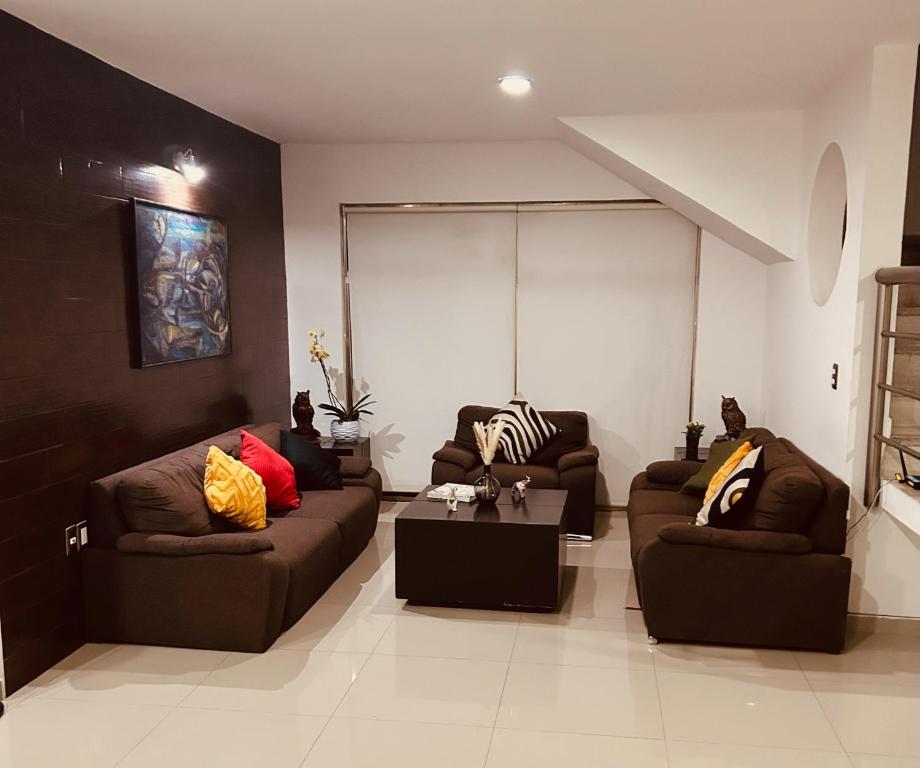 ein Wohnzimmer mit zwei Sofas und einem Couchtisch in der Unterkunft Hermoso Penthouse in Tuxtla Gutiérrez