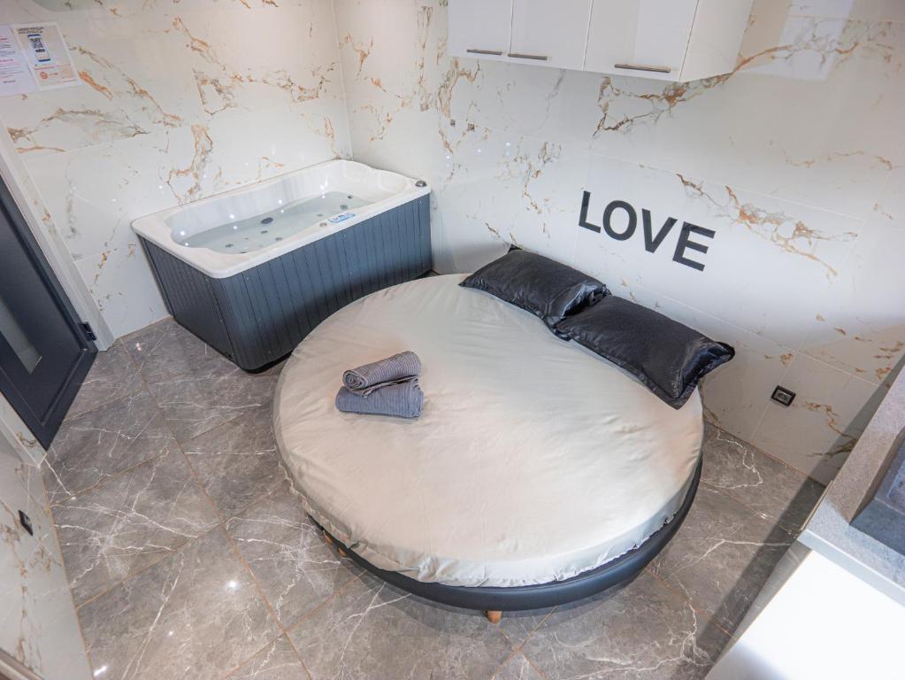 une salle de bain avec un lit rond et une baignoire dans l'établissement Le Topaze - Spa & Jacuzzi, à Manosque