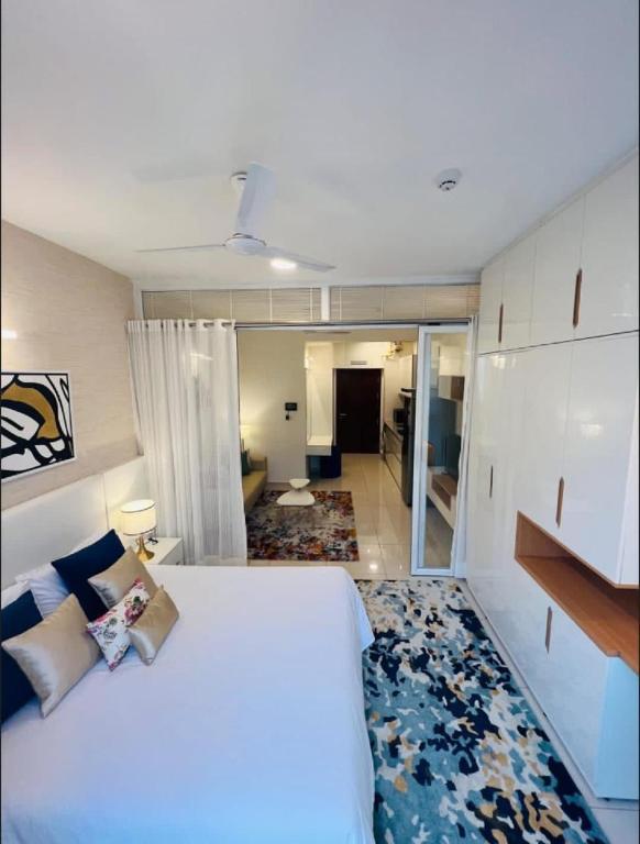 a bedroom with a large bed and a living room at Full 1 BHK near Aster hospital hebbal in Bangalore