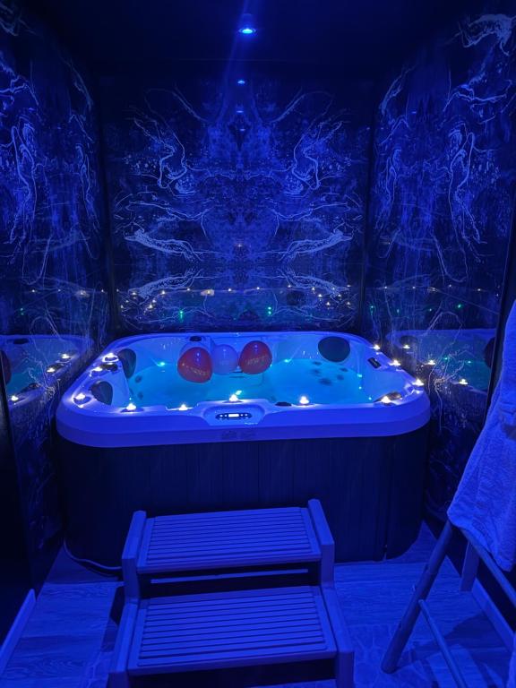 una vasca da bagno in una stanza con luci blu di SPA Rome Antique a Courrières