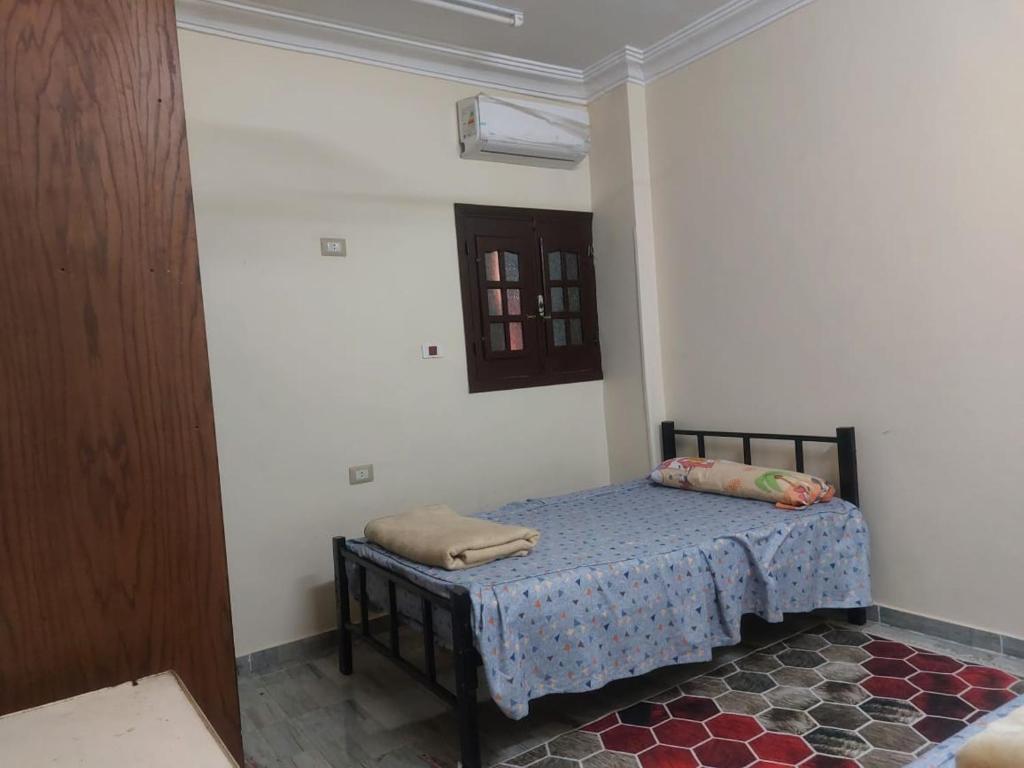 a small bedroom with a bed in a room at Horus apartment in Al Bayāḑīyah