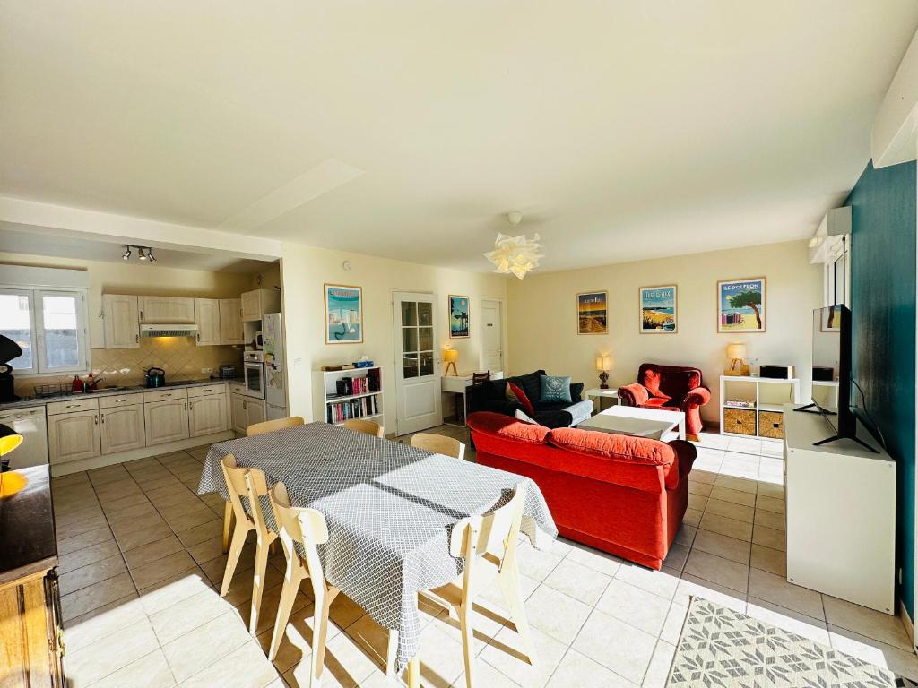 un salon avec un canapé rouge et une table dans l'établissement Maison de vacances 6 pers, proche mer, Fouras - FR-1-709-85, à Fouras